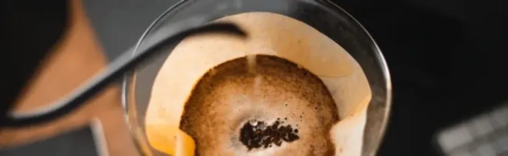 Hot water in being poured on the coffee grounds placed on the coffee filter