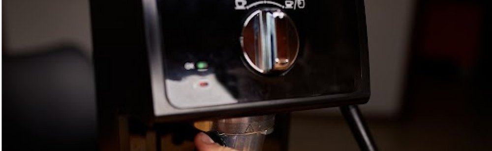 Person filling brewed coffee in cup directly from a coffee maker