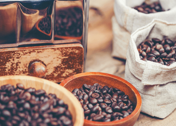 Various types of roasted coffee beans are placed in different bowls