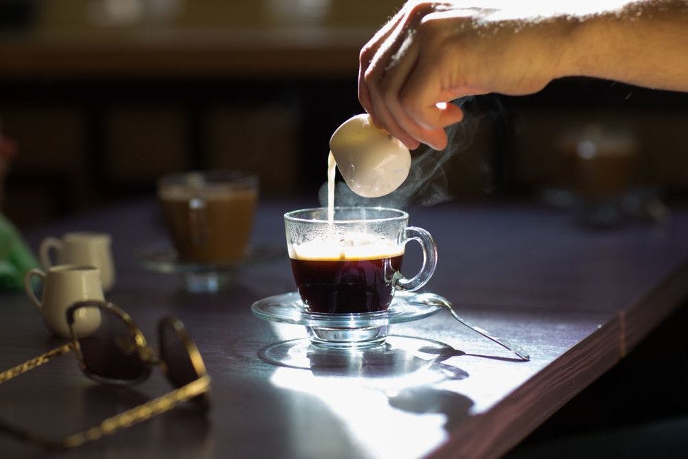 Pouring brewed coffee in cup