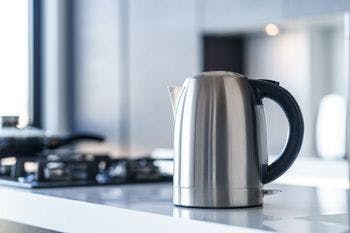 Stovetop coffee percolator placed on a white platform